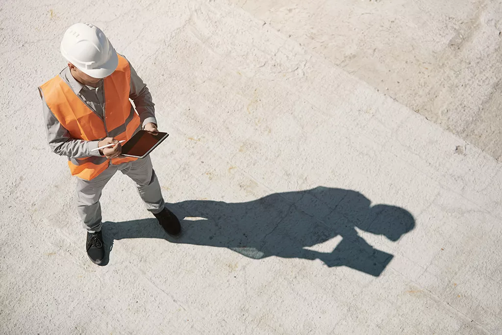 Ingenieur mit Tablet und Helm aus der Vogelperspektive